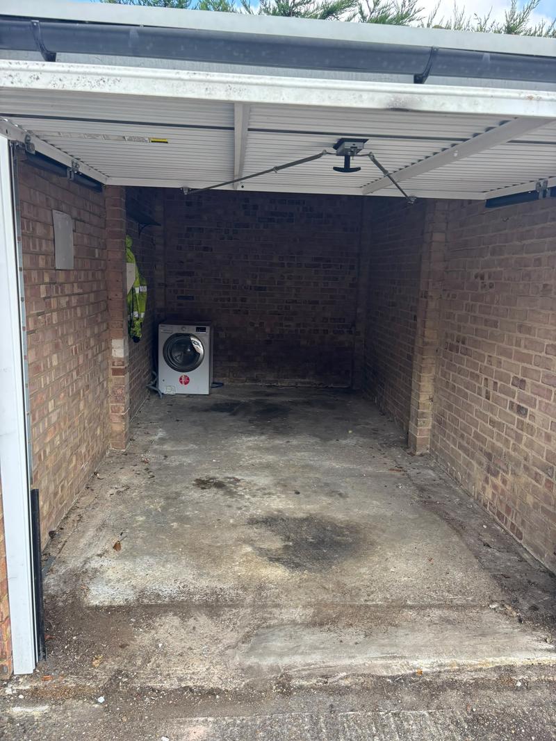 Garage after the loose contents were cleared; a washing machine remains