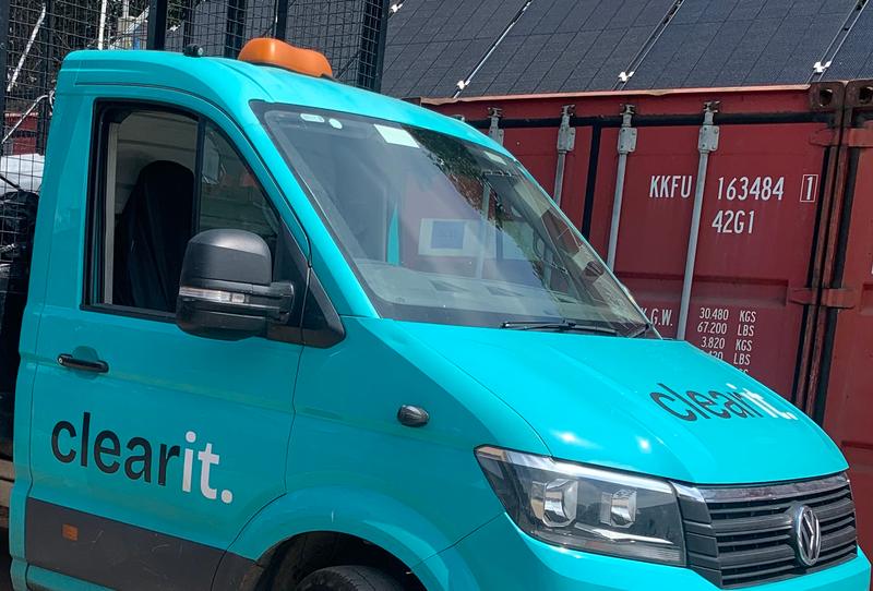Turquoise Clear It van with the company name on its cab